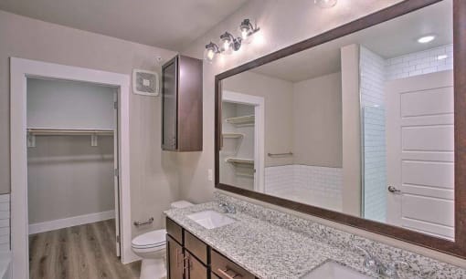 a bathroom with a sink and a large mirror at Hunters Creek Apartments, Denton