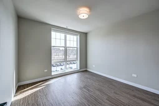 A room with a window overlooking a parking lot.