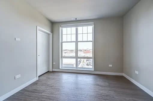 A room with a large window and a view of the city.