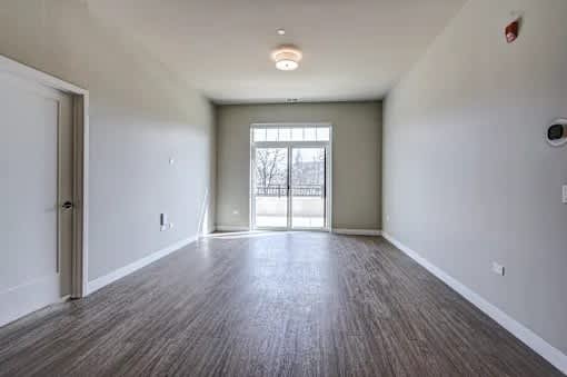 A room with a wooden floor and a sliding glass door.