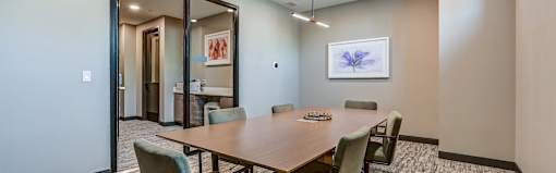 A conference room with a long table and chairs.