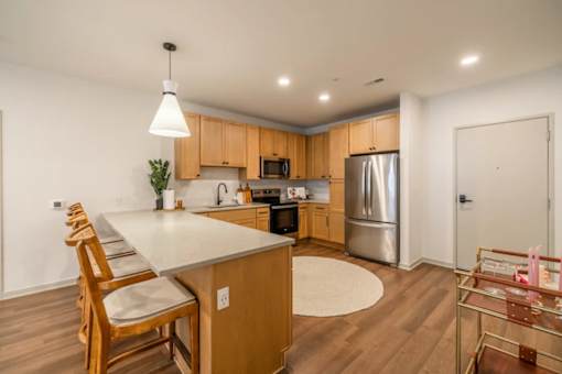 A kitchen with wooden cabinets and a white island.
