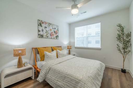 A bedroom with a large bed and a ceiling fan.