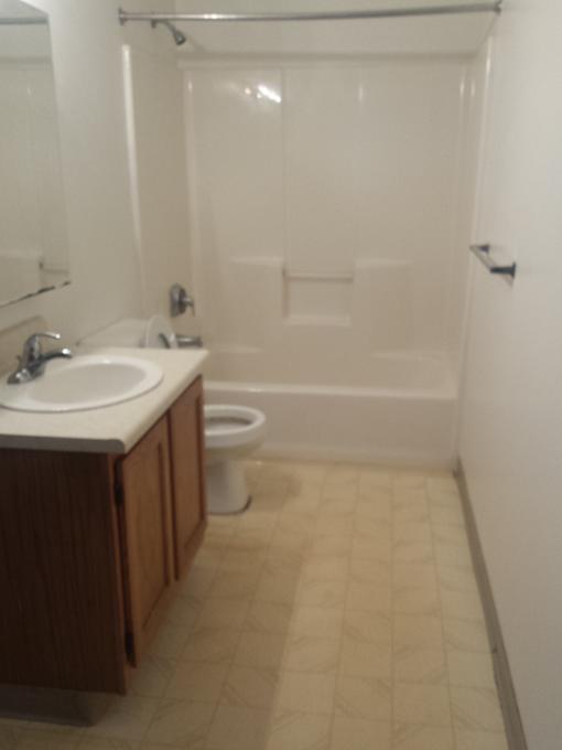 A white bathroom with a white tub and a white sink.