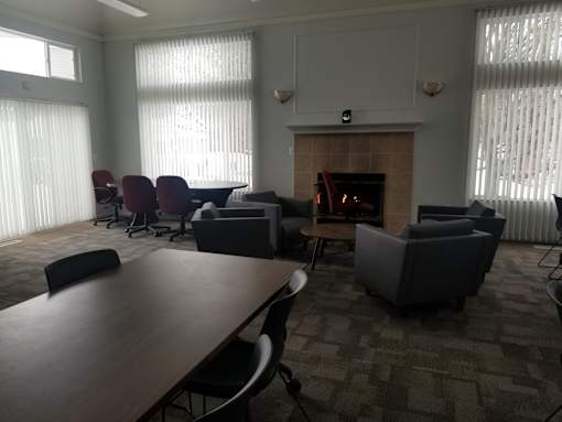 A conference room with a fireplace and chairs.