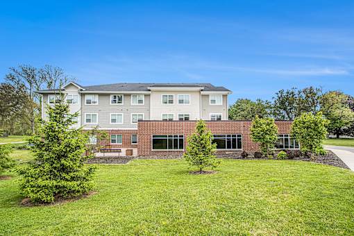 A large building with a grassy front yard.