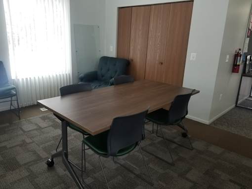 A conference room with a table, chairs, and a couch.