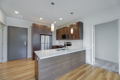a kitchen with a large island and a stainless steel refrigerator at Statesman Apartments, Wisconsin