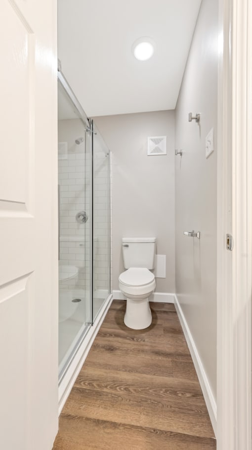 a bathroom with a toilet and a glass shower at Park 44 Apartments, Missouri, 63108