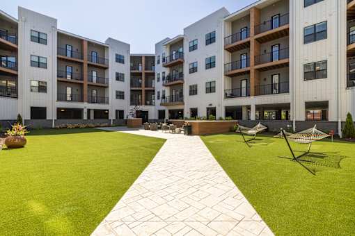 Courtyard with green lawn and paver walkway at Timber Club Apartments, St. Peters