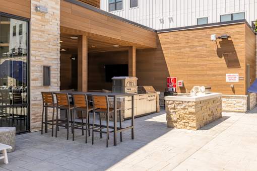 Outdoor kitchen and bar seating area at Timber Club Apartments, St. Peters, Missouri