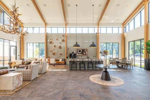 Community lounge with island bar and pendant lighting at Timber Club Apartments, St. Peters, MO 63304
