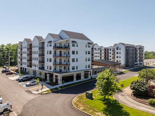 Modern apartment building exterior with parking at Timber Club Apartments, St. Peters, MO