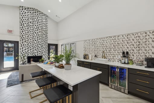 a kitchen with a marble counter top and a dining table at Wellington at Willow Bend Apartments, Plano, TX