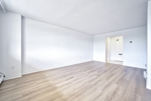 an empty living room with white walls and wood floors