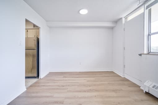 an empty room with white walls and a wooden floor