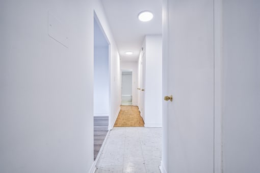 a long white hallway with white walls and white floors and white doors