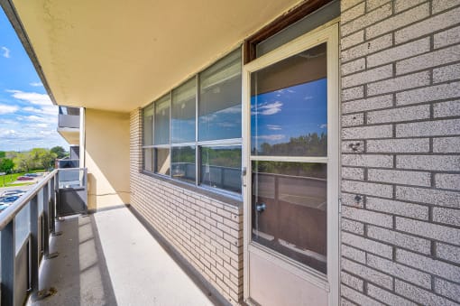 the front porch of a brick building with a glass door