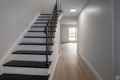 the view from the bottom of the stairs into the hallway of a house
