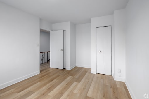 an empty living room with white walls and wooden floors