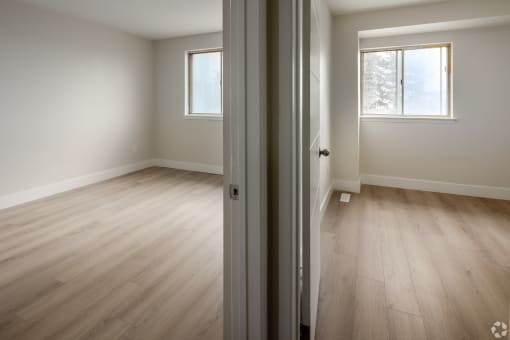 an empty room with wooden floors and a window