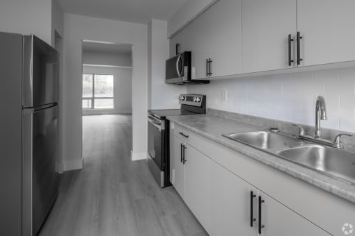 an empty kitchen with a sink and a refrigerator