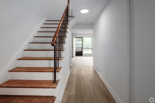 a view of a staircase in a home with white walls and wood floors