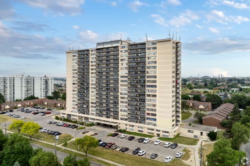 an aerial view of an apartment building with cars parked in a parking lot