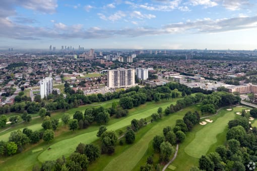 an aerial view of a golf course with the skyline in the background