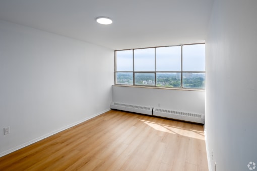 a living room with a large window and wooden floors