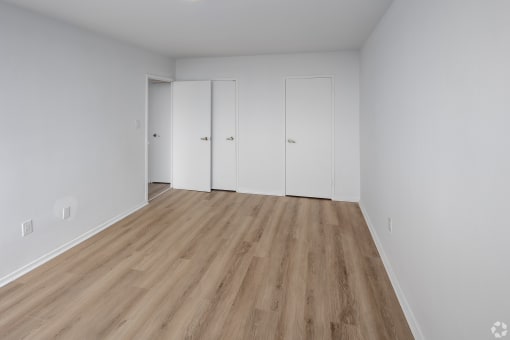 an empty room with white walls and wooden floors