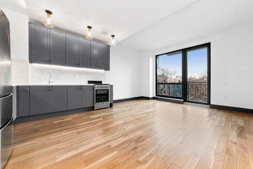 A kitchen with wooden floors and a large window.
