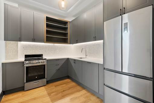 A modern kitchen with a stainless steel refrigerator and a built-in oven.