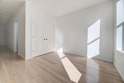 an empty living room with white walls and wood floors