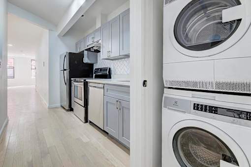 a laundry room with a washer and dryer and a refrigerator