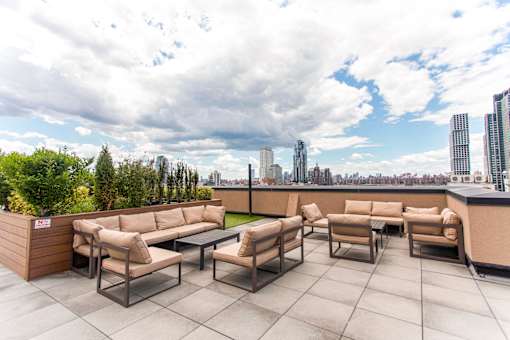 A rooftop patio with a view of the city skyline.