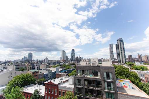 A cityscape with a mix of modern and older buildings under a partly cloudy sky.