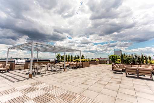 A rooftop patio with a table and chairs.