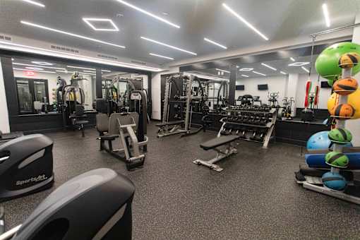 A gym with a variety of equipment including weights and machines.