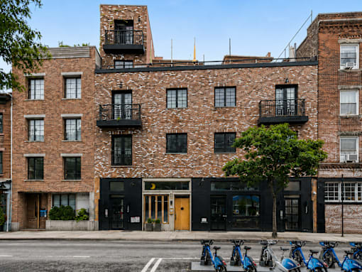 A row of bikes are parked in front of a building.