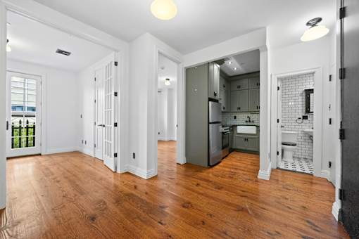 A kitchen with a wooden floor and white walls.
