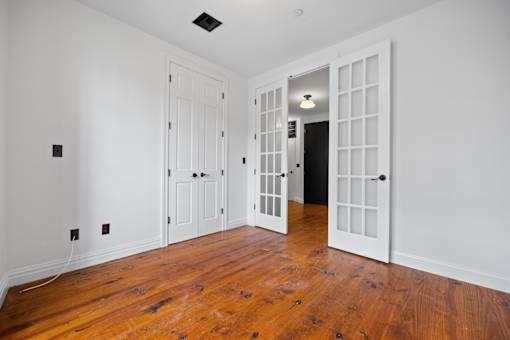 A room with a white door and a black door with a light on.