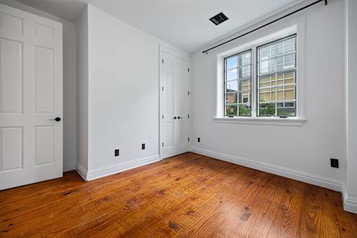 A room with a window and wooden floors.