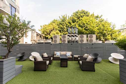 Outdoor terrace with lounge seating and privacy fence at 1134 Fulton Street Apartments, New York, 11216