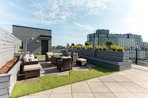 Rooftop terrace with lounge seating and artificial grass at 1134 Fulton Street Apartments, Brooklyn, New York