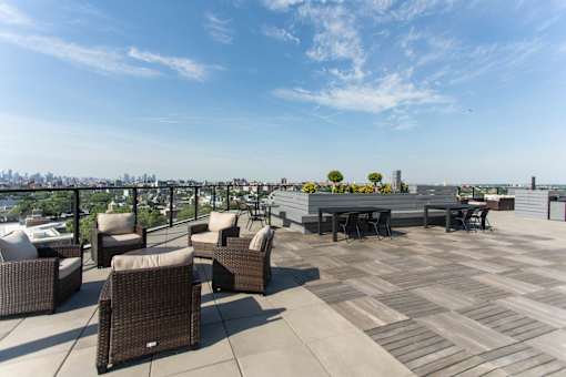 Rooftop deck with skyline views and dining areas at 1134 Fulton Street Apartments, Brooklyn