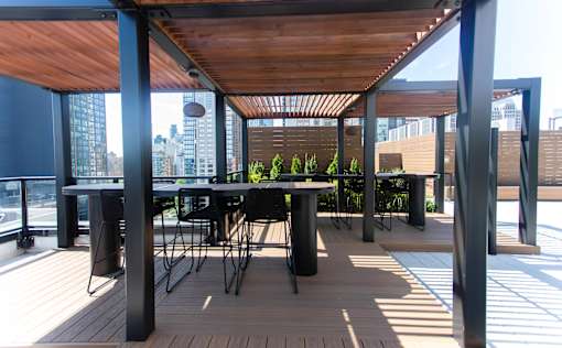 Rooftop pergola with dining space and wood slat ceiling at 260 Gold Apartments, Brooklyn, New York