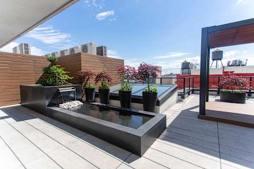 Rooftop water feature with planters and wood privacy screen at 260 Gold Apartments, Brooklyn