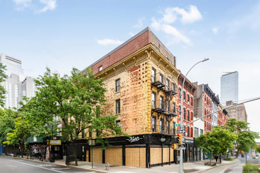 A large brick building with a black awning on the corner of a street.