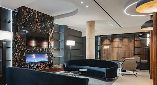 Resident lounge with fireplace and curved sofa at 260 Gold Apartments, Brooklyn, 11201